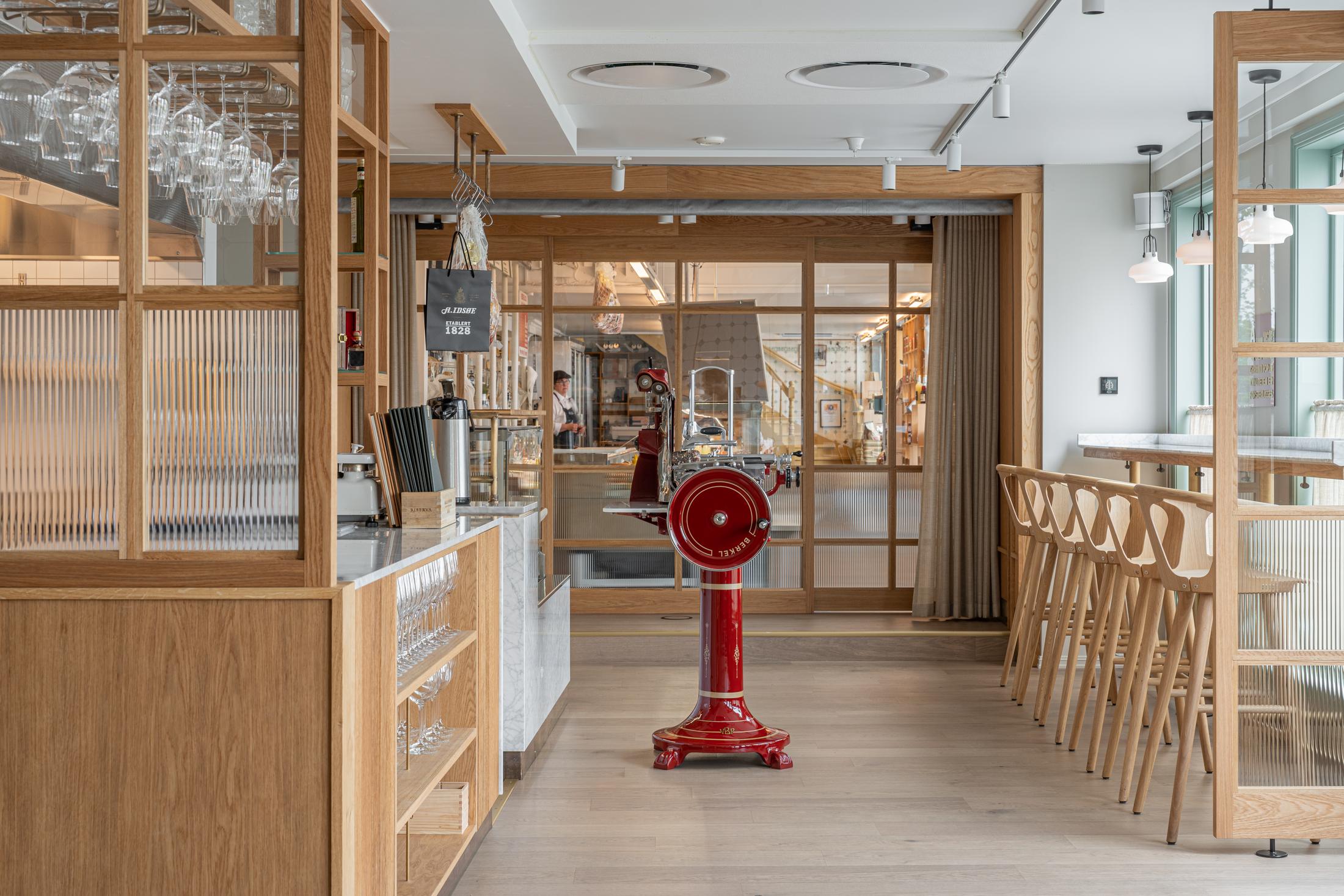 Restaurant og slakteri innredet med tre og rillet glass. Foto