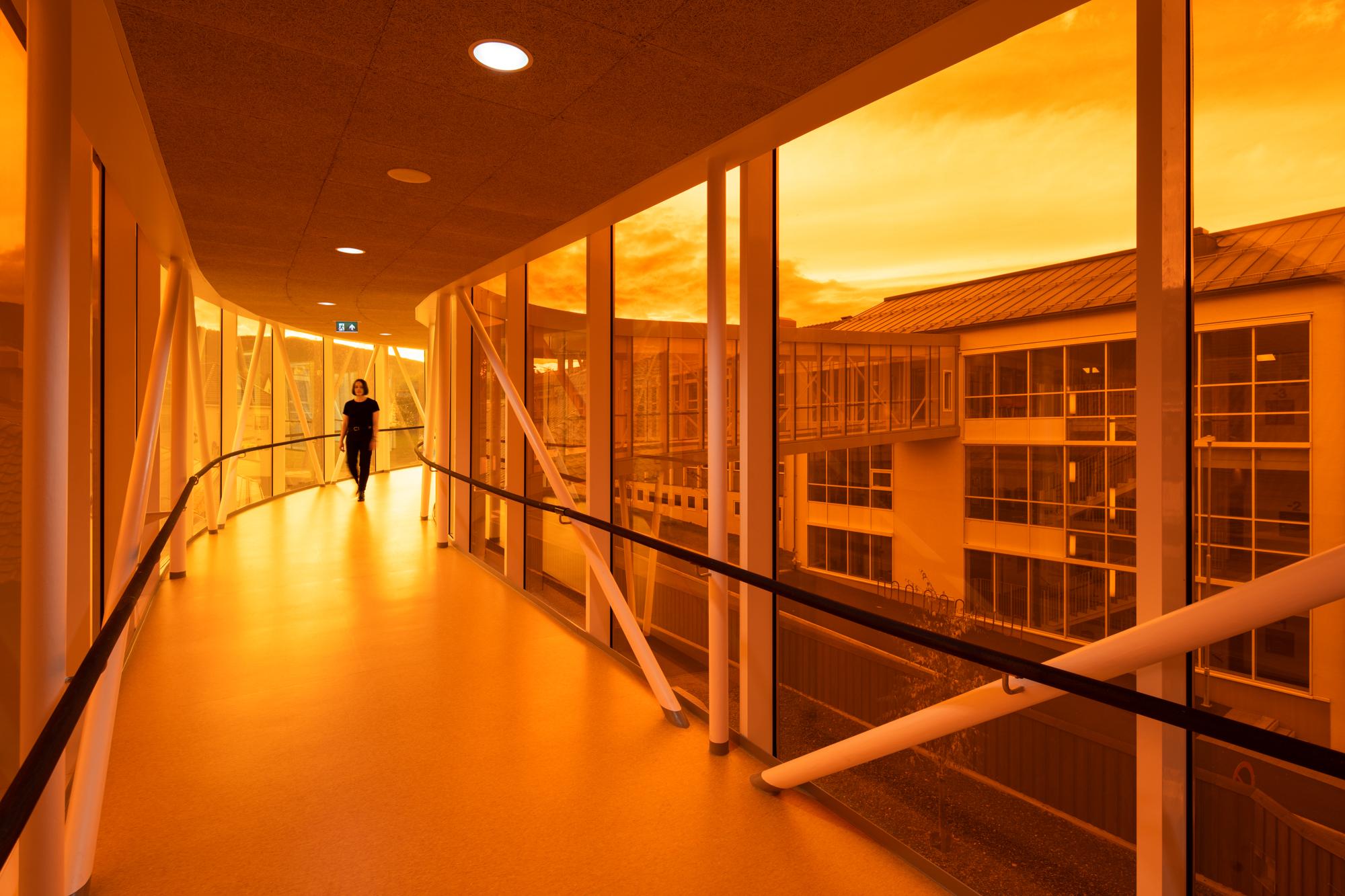 Innvendig gangbro i glass med gule, oransje og røde nyanser, Foto
