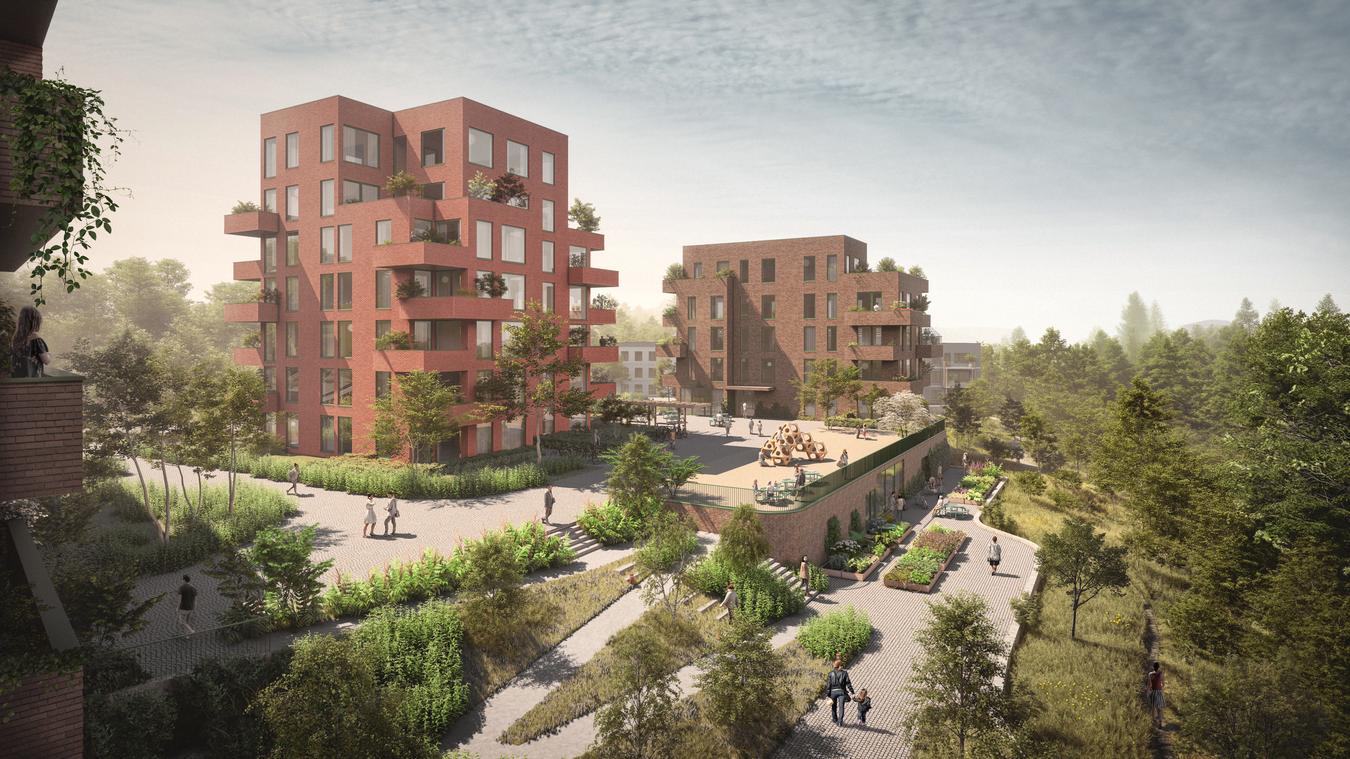 To boligblokker i rød tegl på toppen av en kolle med grønne omgivelser.