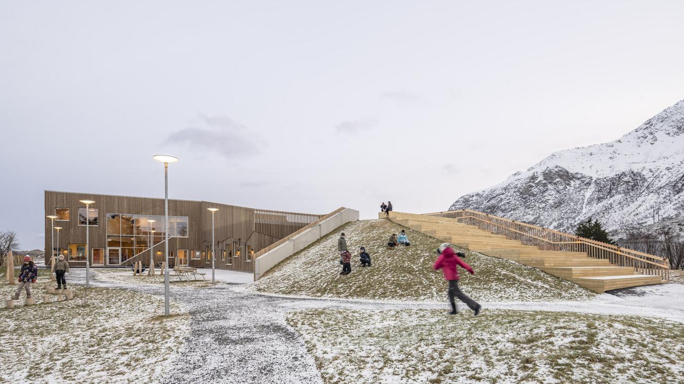 Skolebygg med akebakke som en integrert del av tak og landskap. Foto