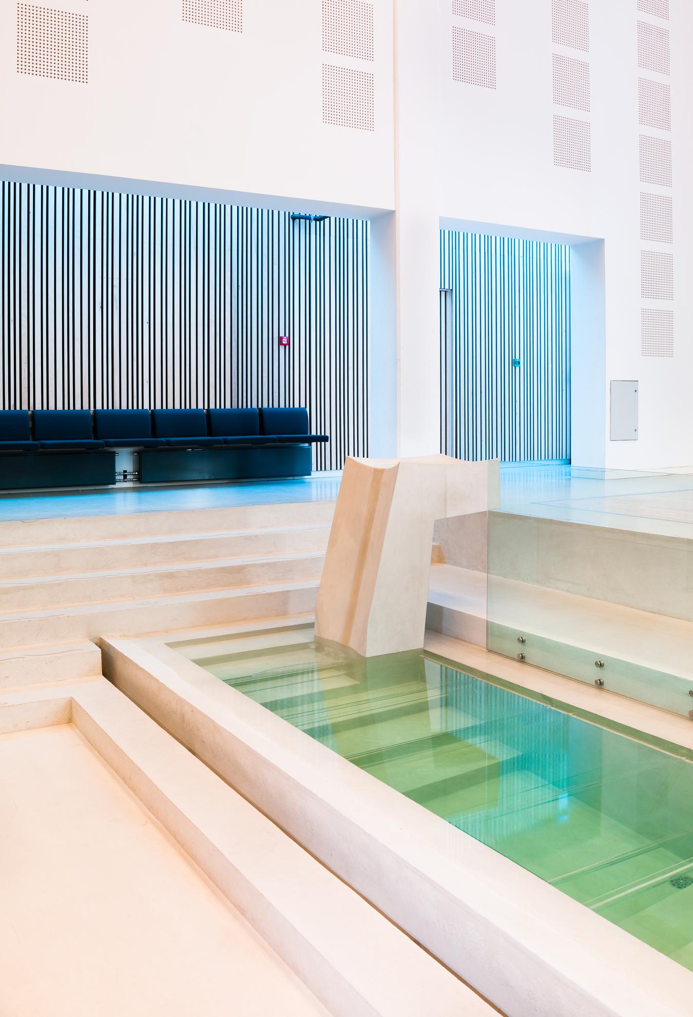 Indoor baptismal pool in light stone. Photo