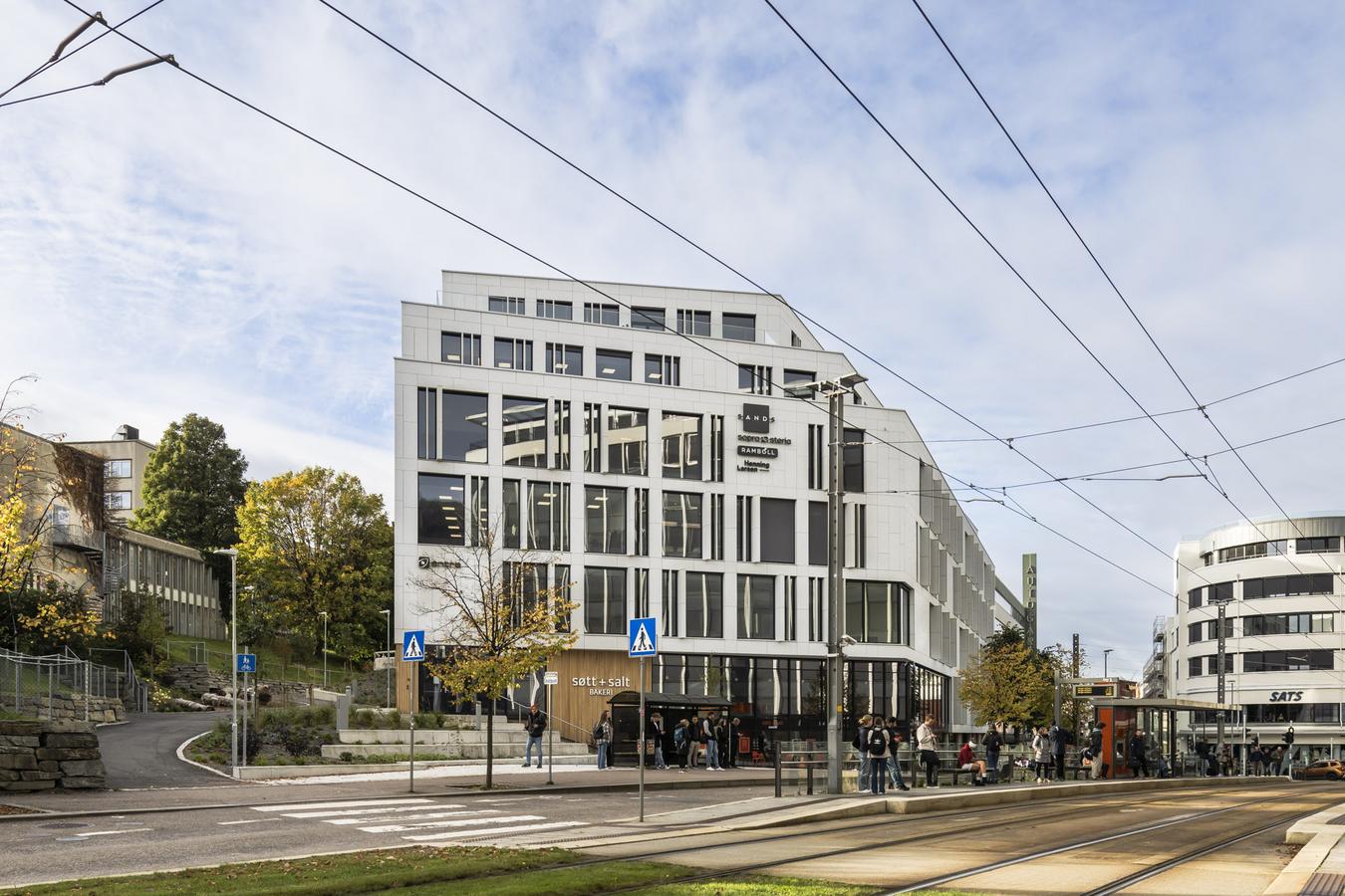 Hvitt kontorbygg i bymiljø. Foto